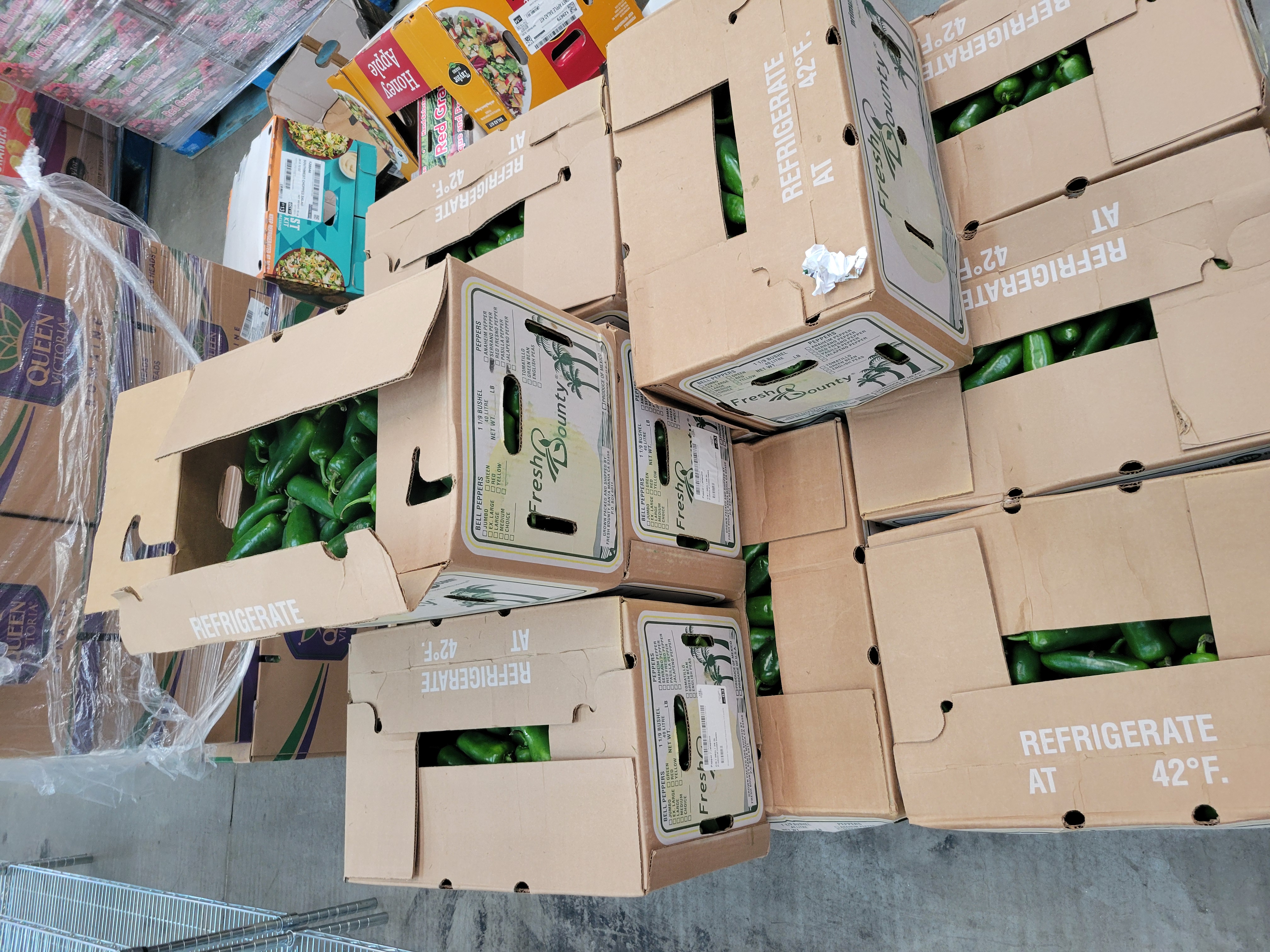 Cardboard boxes of serrano peppers on a pallet.